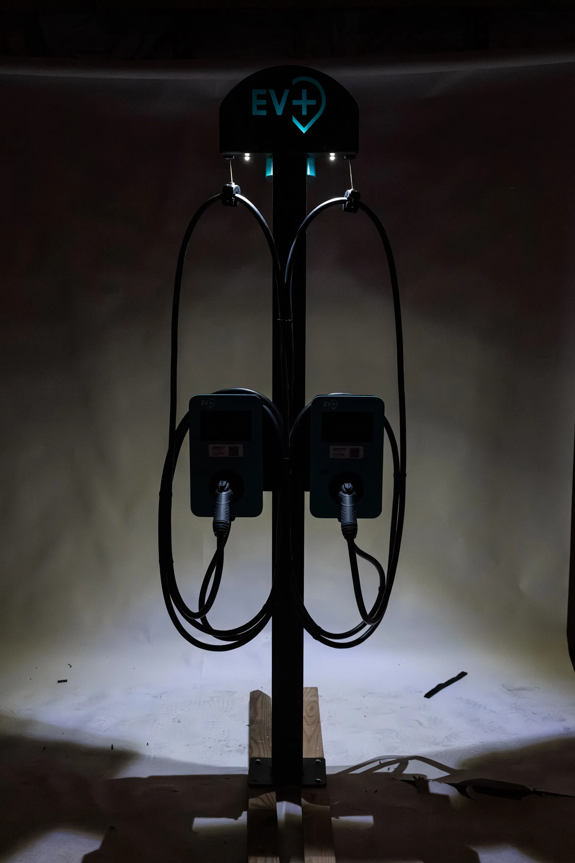 Licensed electrician installing an EV+ commercial Level 2 charging bundle at a commercial parking lot